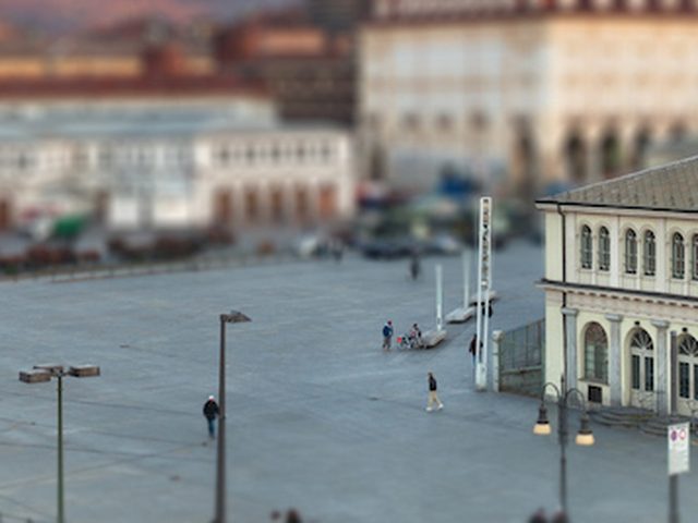 Piazza storica di Torino vista dall’alto, con un edificio ottocentesco e il tram sullo sfondo